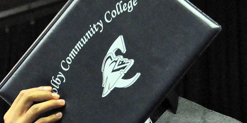 Student holding a ̳ diploma cover
